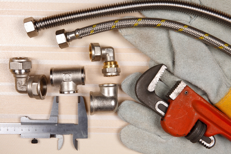 Plumber working on pipes in a Dartford home